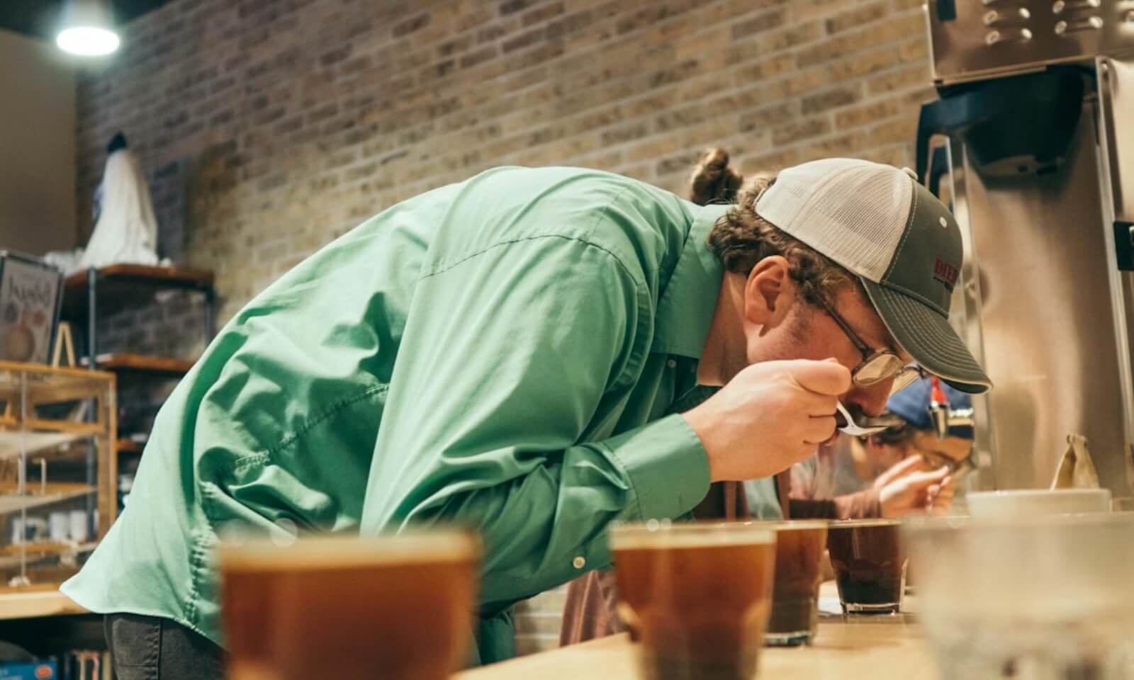 Nếm vị bằng cách slurp cà phê từ thìa, đánh giá độ chua, ngọt, đắng và các note trái cây, caramel